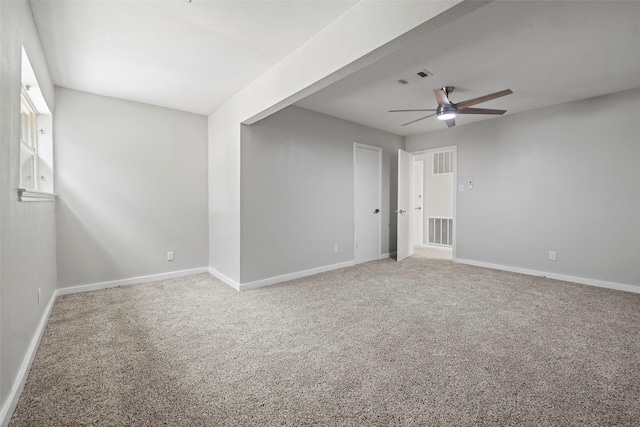 carpeted empty room featuring baseboards, visible vents, and a ceiling fan