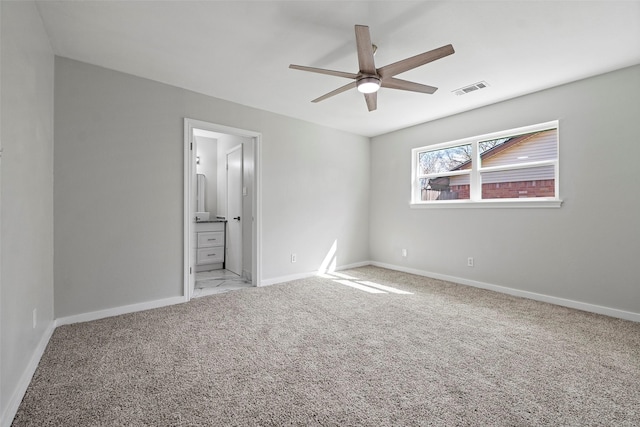 unfurnished bedroom with visible vents, baseboards, light colored carpet, ceiling fan, and ensuite bathroom