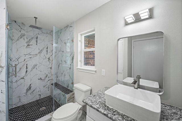 bathroom featuring vanity, a marble finish shower, and toilet