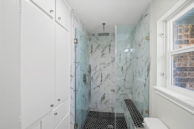 full bath with toilet and a marble finish shower