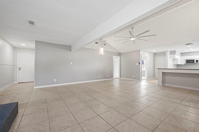 unfurnished living room featuring light tile patterned floors, baseboards, a ceiling fan, lofted ceiling with beams, and a textured ceiling