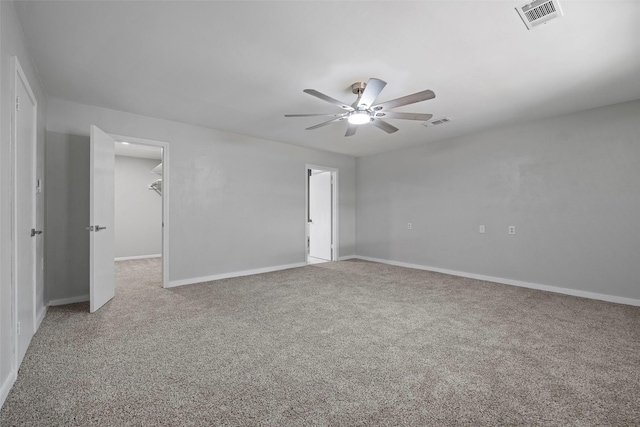 carpeted empty room with a ceiling fan, visible vents, and baseboards