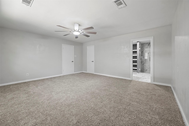 carpeted empty room with visible vents, ceiling fan, and baseboards