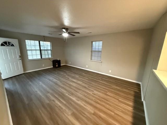 interior space with dark wood-type flooring, ceiling fan, and a healthy amount of sunlight