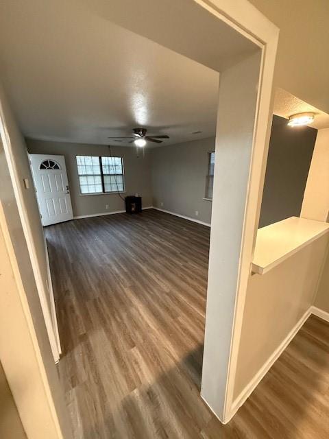 unfurnished living room with ceiling fan and dark hardwood / wood-style floors