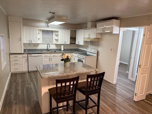 kitchen with sink, white appliances, a breakfast bar, white cabinets, and dark hardwood / wood-style flooring