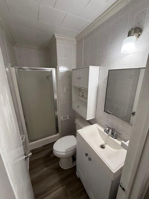 bathroom featuring tile walls, vanity, wood-type flooring, and walk in shower