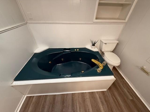 bathroom featuring toilet, a bathing tub, and hardwood / wood-style floors