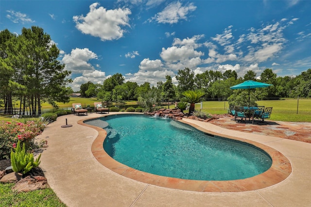 view of pool with pool water feature, a patio area, and a lawn