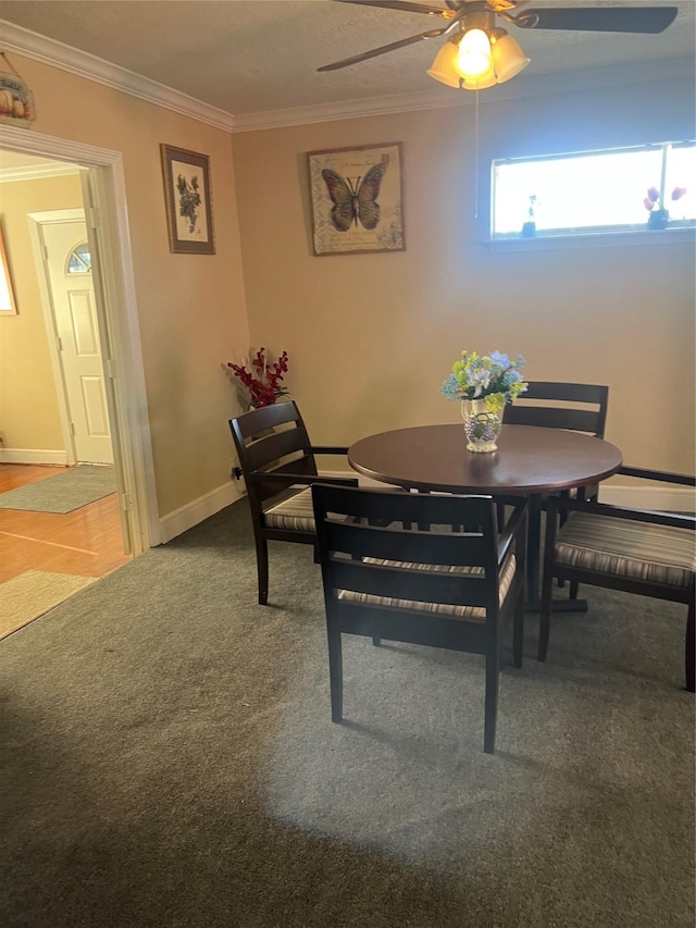 dining space featuring crown molding, carpet floors, and ceiling fan