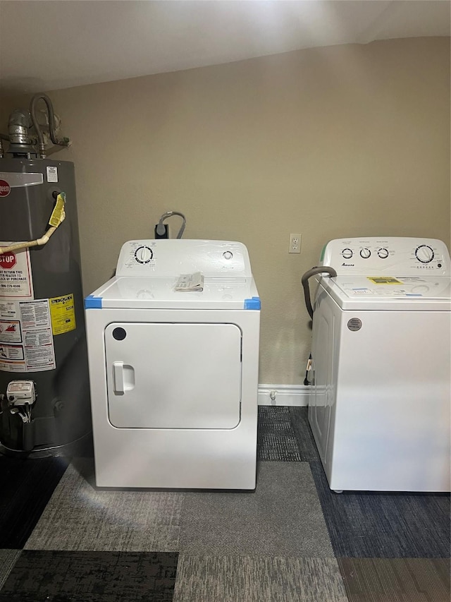 clothes washing area featuring water heater and washer and dryer