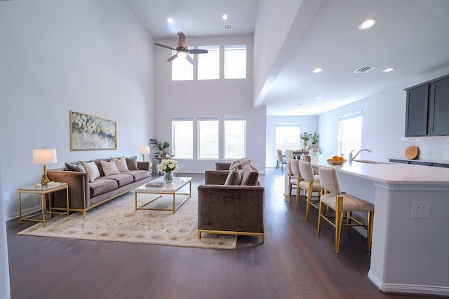 living room with recessed lighting, a high ceiling, dark wood-style flooring, visible vents, and a ceiling fan