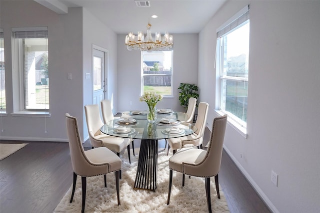 dining space featuring a notable chandelier, visible vents, baseboards, and wood finished floors