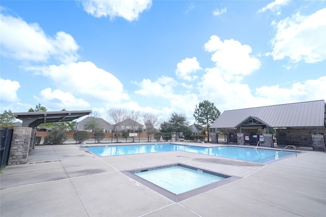 pool featuring a hot tub, fence, and a patio