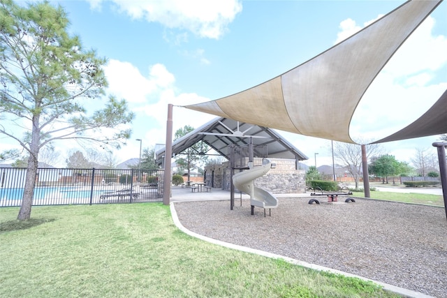 exterior space with fence, a playground, and a yard