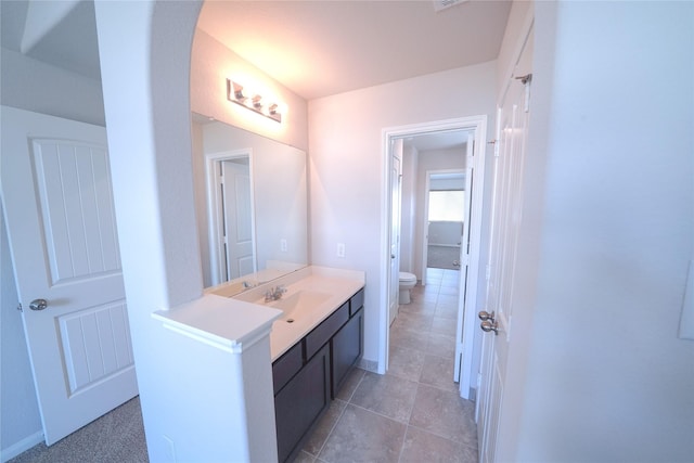 bathroom with toilet, baseboards, and vanity