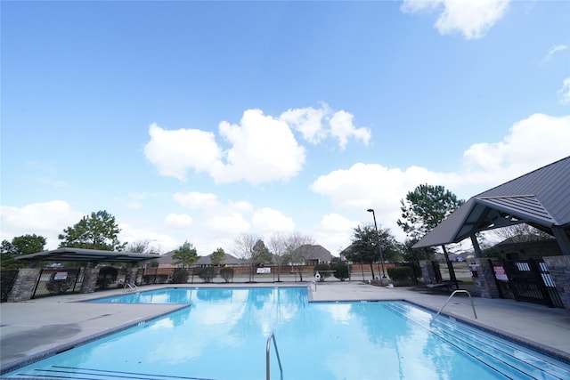 pool with fence and a patio