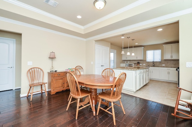 dining area with ornamental molding, sink, and hardwood / wood-style floors