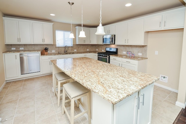 kitchen with white cabinetry, sink, a center island, and appliances with stainless steel finishes