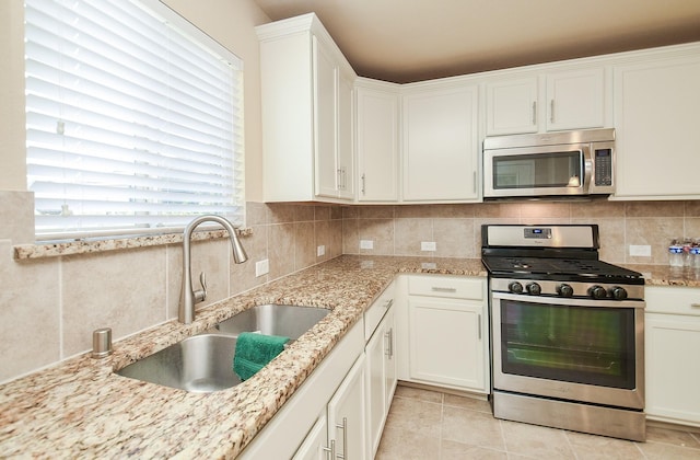 kitchen featuring white cabinetry, appliances with stainless steel finishes, sink, and backsplash