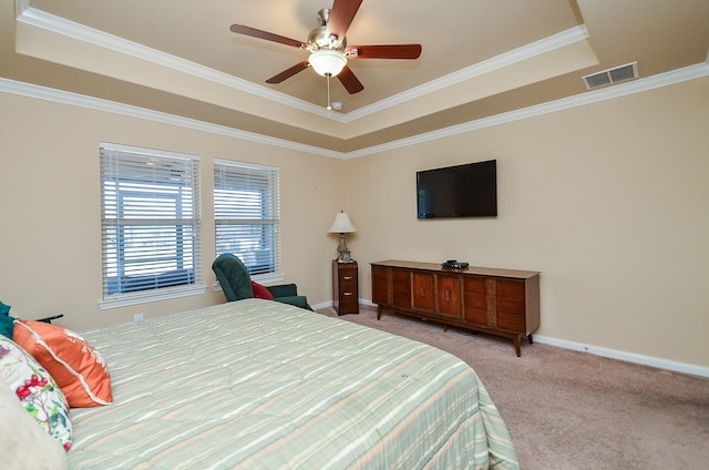 bedroom featuring ornamental molding, light carpet, ceiling fan, and a tray ceiling