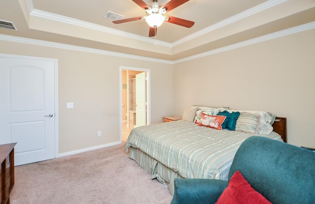 bedroom with ceiling fan, ensuite bathroom, ornamental molding, light carpet, and a raised ceiling