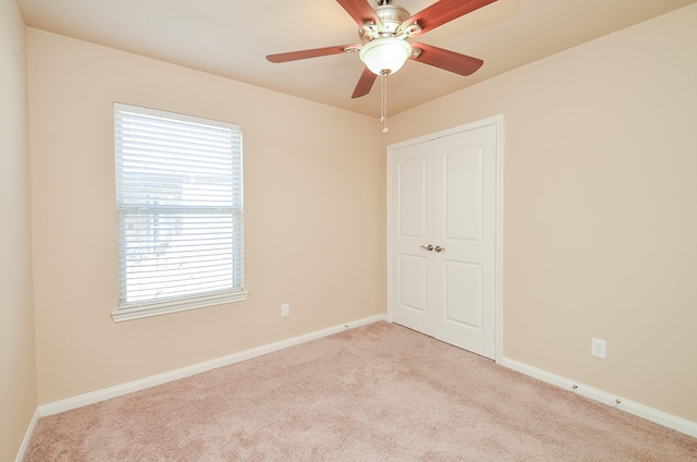 carpeted empty room featuring ceiling fan