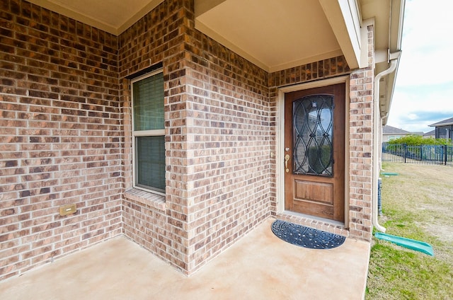 view of exterior entry with a patio