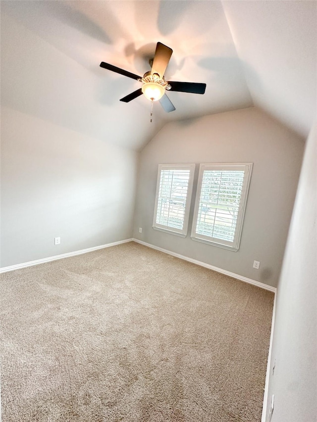 empty room featuring vaulted ceiling, ceiling fan, and carpet