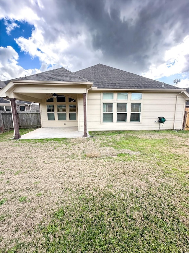 back of property with a yard, a patio area, and ceiling fan