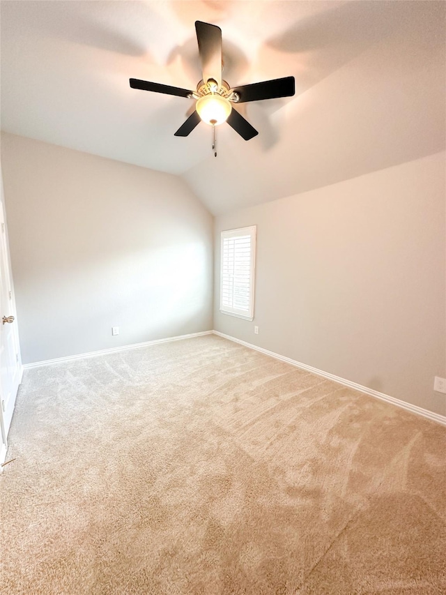 carpeted empty room featuring vaulted ceiling and ceiling fan