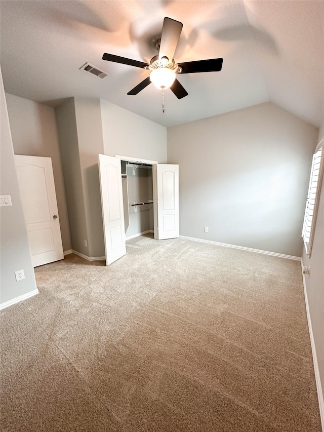 unfurnished bedroom with vaulted ceiling, carpet floors, ceiling fan, and a closet