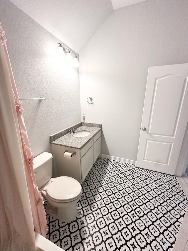 bathroom featuring vanity, lofted ceiling, and toilet