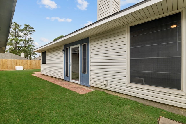 exterior space featuring a lawn, a chimney, and fence