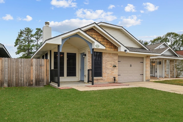 view of front facade with driveway, a front lawn, an attached garage, and fence