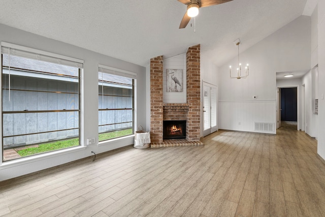 unfurnished living room with visible vents, vaulted ceiling, and a textured ceiling