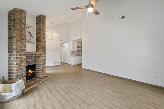 unfurnished living room featuring light wood-type flooring, a brick fireplace, and visible vents