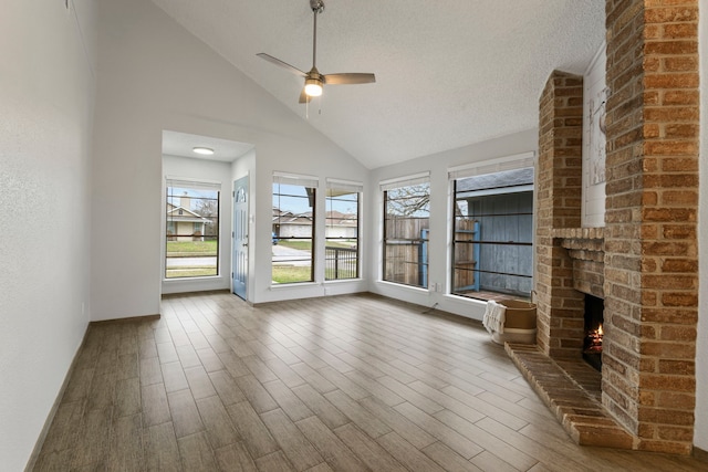 unfurnished sunroom featuring lofted ceiling, a brick fireplace, and ceiling fan