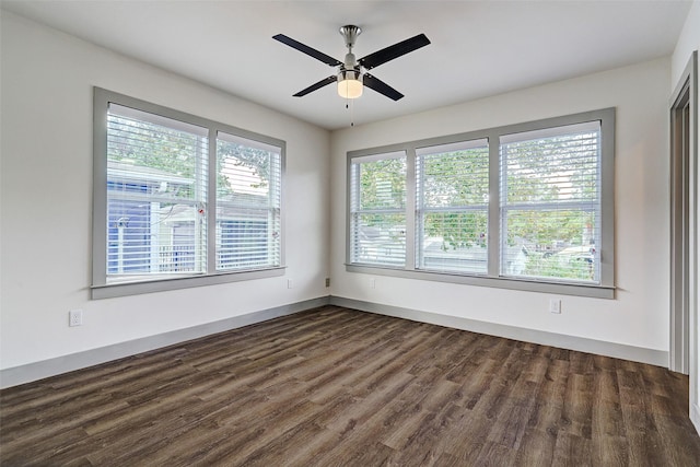 spare room featuring dark wood-type flooring and ceiling fan