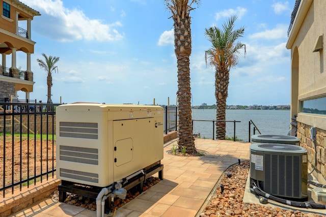 view of patio / terrace featuring central AC and a water view