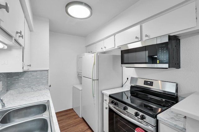 kitchen with tasteful backsplash, white cabinets, stainless steel appliances, light countertops, and a sink