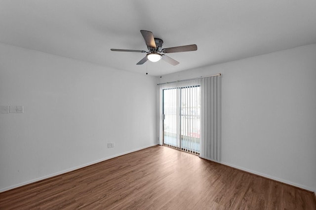 unfurnished room with wood finished floors, a ceiling fan, and baseboards