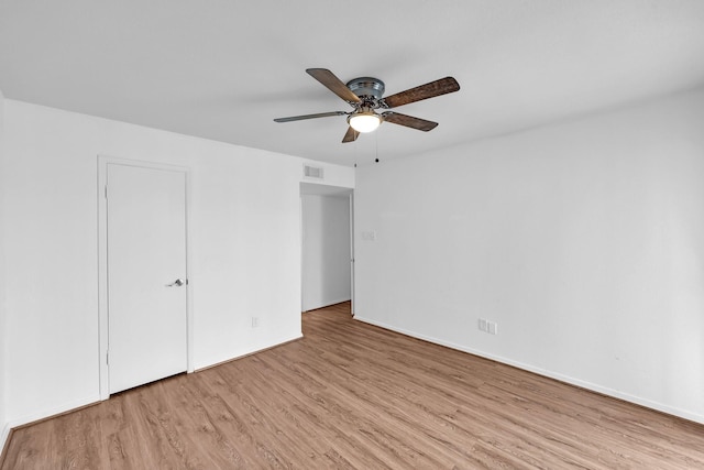 unfurnished bedroom with a ceiling fan, baseboards, visible vents, and wood finished floors