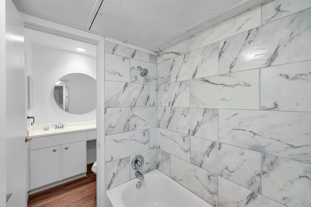 bathroom featuring shower / bathtub combination, wood finished floors, and vanity