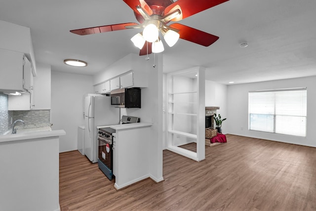 kitchen featuring appliances with stainless steel finishes, backsplash, white cabinets, ceiling fan, and light wood-type flooring