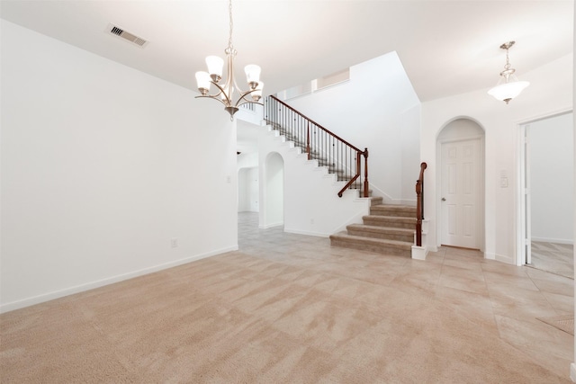 unfurnished living room with light carpet and a notable chandelier