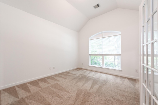 spare room with vaulted ceiling and carpet floors