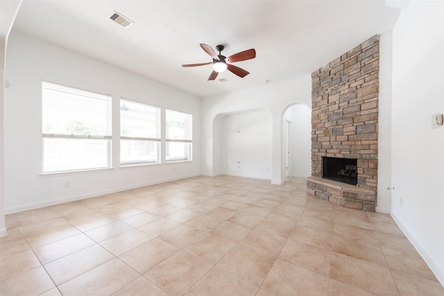 unfurnished living room with light tile patterned floors, a fireplace, and ceiling fan