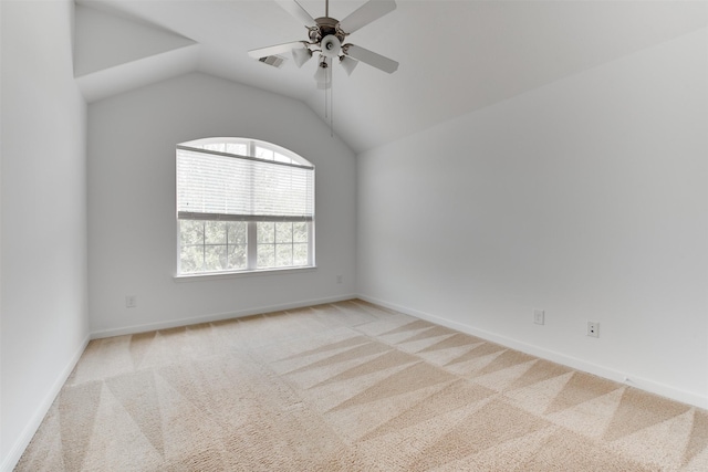 empty room featuring vaulted ceiling, light carpet, and ceiling fan