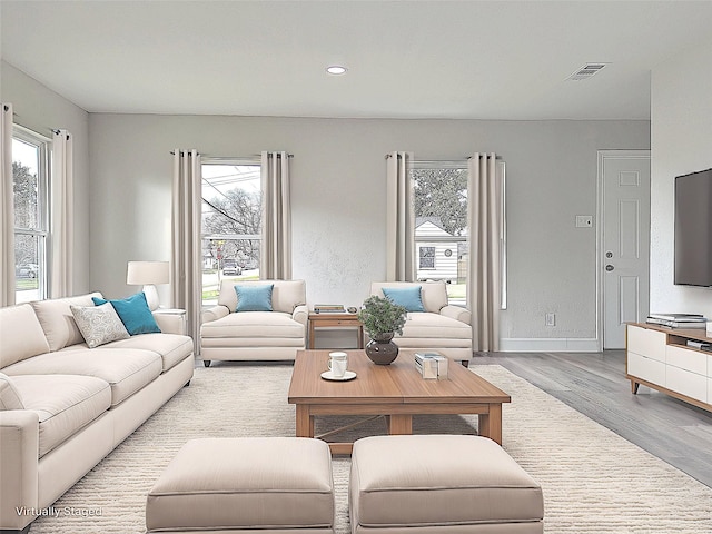 living room with a wealth of natural light and light hardwood / wood-style floors